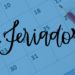 Calendário com lápis vermelho e palavra feriado em destaque