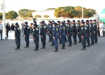 Guarda Municipal perfilada em cerimônia ao ar livre com público ao fundo.