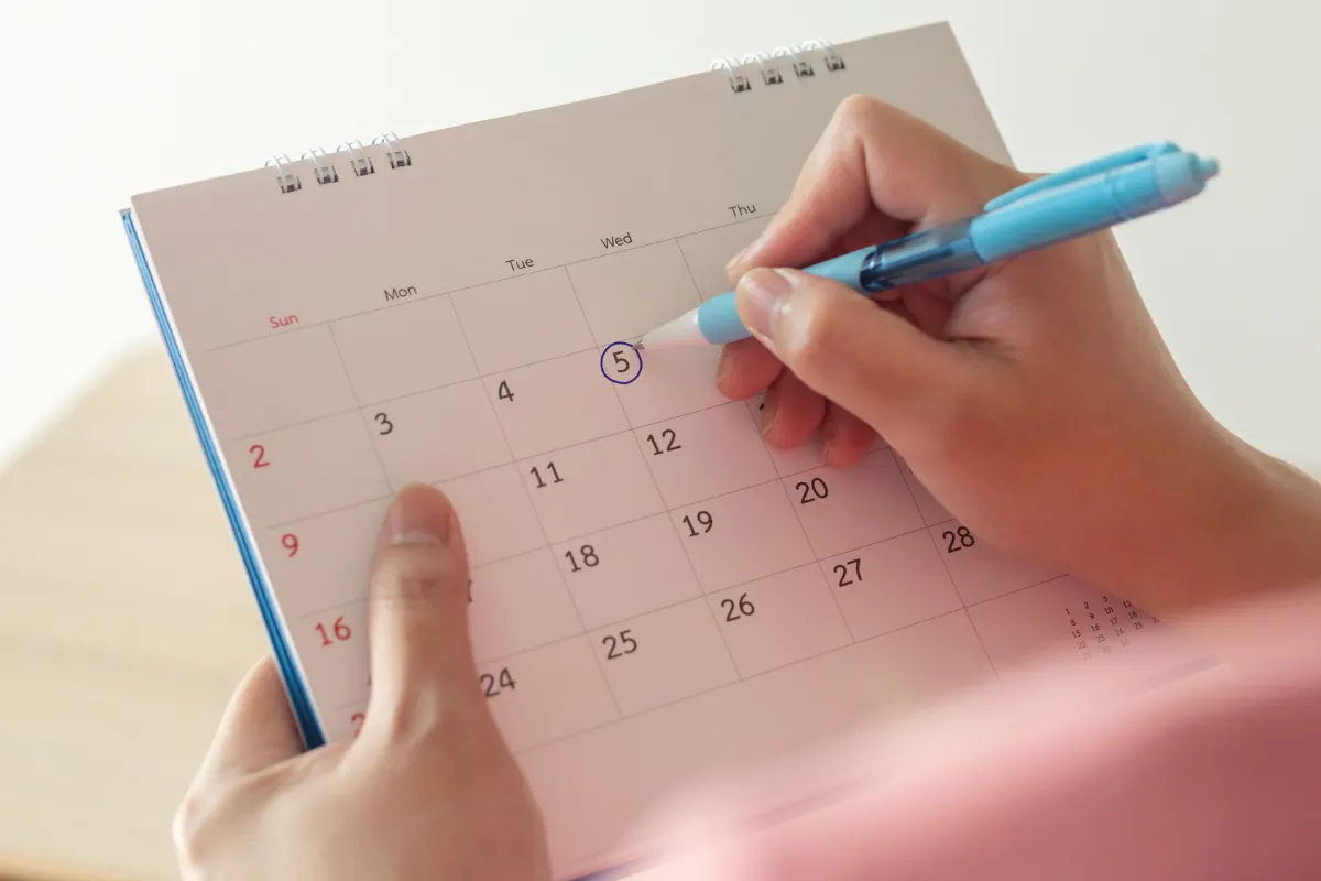 calendário de provas cnu 2025 Pessoa marcando uma data no calendário com caneta azul