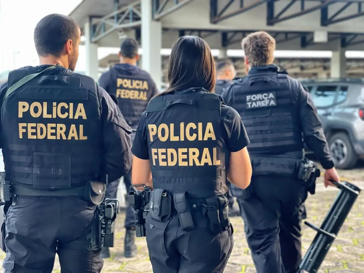 Concurso PF Agentes da Polícia Federal e Força-Tarefa caminham em formação durante operação.