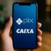 Imagem de um smartphone mostrando os logos do Pix e da CAIXA, representando a liberação de valores pelo banco.