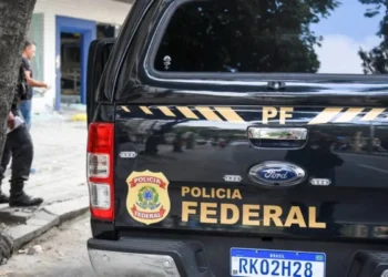 Policiais rodoviários federais em frente à base da PRF, representando a força e segurança das rodovias no Brasil, e os salários atualizados de 2025