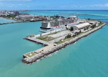 Vista aérea do porto de Maceió com cruzeiro atracado e mar azul-turquesa.