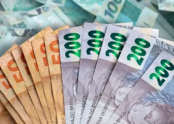 Notas de 50 e 200 reais em destaque, com foco na cédula de 200 reais, representando o saque de R$ 6.220 da CAIXA.