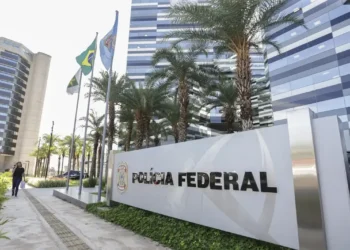 Fachada da sede da Polícia Federal em Brasília com bandeiras hasteadas.