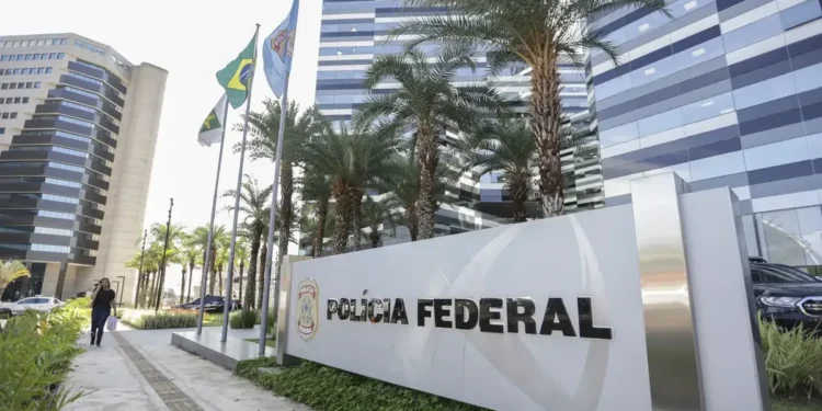 Fachada da sede da Polícia Federal em Brasília com bandeiras hasteadas.