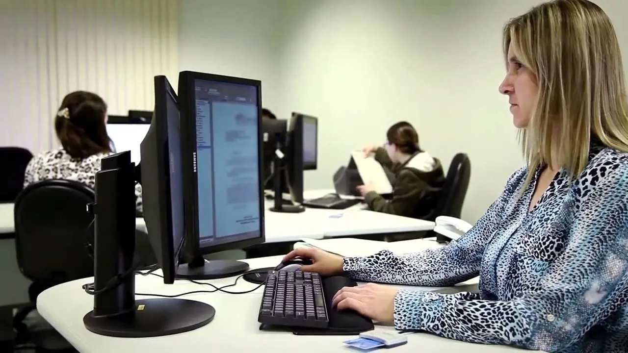Escrevente Técnico Judiciário Servidora pública digitando em computador no ambiente de trabalho