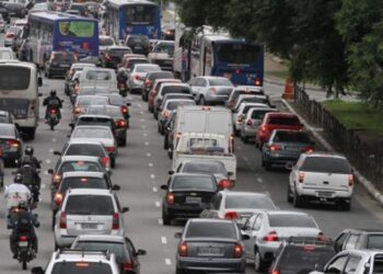Engarrafamento com carros, motos e ônibus na Marginal Pinheiros em São Paulo durante o dia.