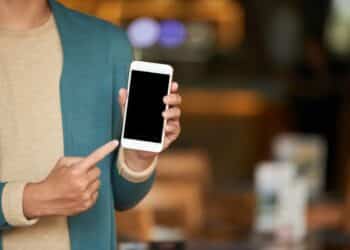 Pessoa mostrando tela do iPhone com funcionalidades ocultas do iOS