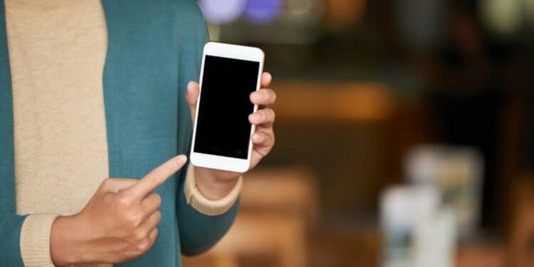 Pessoa mostrando tela do iPhone com funcionalidades ocultas do iOS