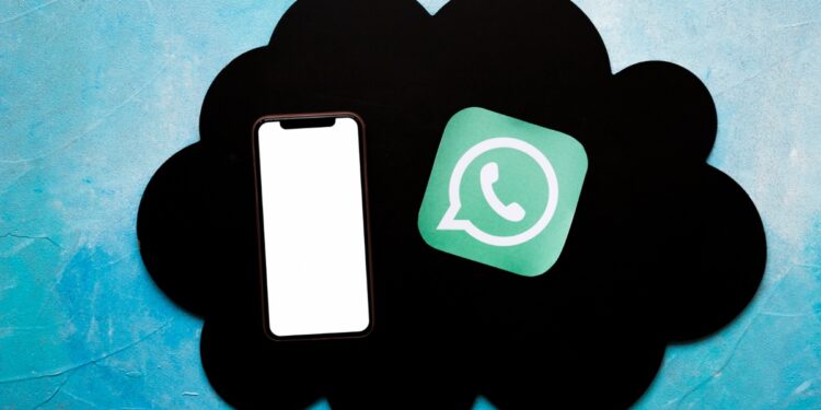 Celular e ícone WhatsApp sobre nuvem negra em fundo azul representando sincronização