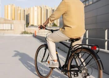 Trabalhador pedalando bicicleta em ambiente urbano durante deslocamento para o trabalho