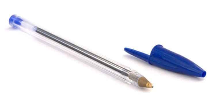 Tampa azul de caneta esferográfica com um pequeno buraco, ao lado do corpo transparente da caneta.