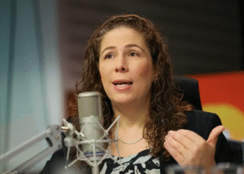 Mulher falando em microfone profissional de estúdio durante entrevista ou pronunciamento oficial