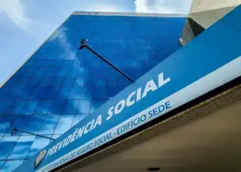 Edifício sede da Previdência Social com fachada azul espelhada moderna representando mudanças administrativas