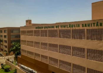 Sede da ANVISA, instituição responsável pela vigilância sanitária no Brasil, com edifício visível e céu claro ao fundo.