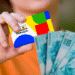 Cartão do programa Bolsa Família segurado por uma pessoa ao lado de cédulas de dinheiro em reais.