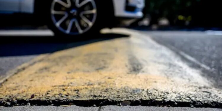 Pneu de carro parado sobre um quebra-mola (lombada).