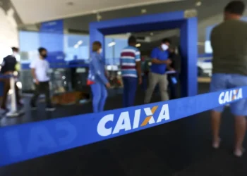 Pessoas na fila do banco Caixa Econômica Federal aguardando atendimento.