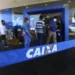 Pessoas na fila do banco Caixa Econômica Federal aguardando atendimento.