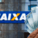 Mão exibindo cédulas de cem reais brasileiros em frente à fachada azul característica de agência CAIXA Econômica Federal