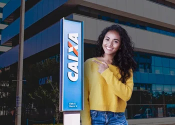 Imagem de uma mulher sorrindo e apontando para o logo da CAIXA. A imagem está destacando a informação sobre o saque de R$ 6.220 que pode ser solicitado até o dia 23/09 por novos CPFs.