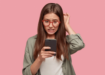 Mulher frustrada com conexão Wi-Fi lenta verificando configurações no celular para melhorar sinal