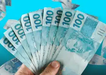 Imagem de notas de R$ 100 com destaque para a quantidade de dinheiro, relacionada ao novo auxílio mensal de R$ 900.