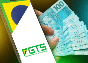 Celular com aplicativo FGTS e notas de 100 reais, ilustrando saque autorizado para pensão.