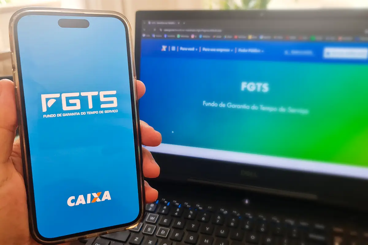Consulta do FGTS pelo celular e site, com o aplicativo FGTS da Caixa em uso e página do site do FGTS aberta.