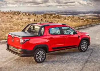 Fiat Strada vermelha 2025, com capota na caçamba, estacionada em uma estrada, destacando-se no ranking de carros mais vendidos do Brasil em agosto de 2025 com 11.833 unidades comercializadas.