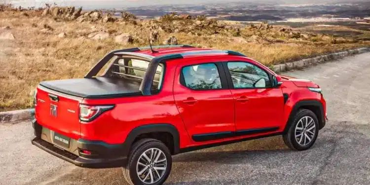 Fiat Strada vermelha 2025, com capota na caçamba, estacionada em uma estrada, destacando-se no ranking de carros mais vendidos do Brasil em agosto de 2025 com 11.833 unidades comercializadas.