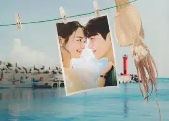 Cena romântica de Hometown Cha-Cha-Cha, com os personagens principais sorrindo um para o outro ao fundo de um cenário costeiro.