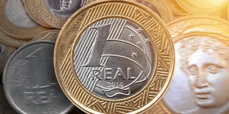 Moeda de 1 real brasileira de 2014 entre outras moedas, com detalhes em dourado e prata
