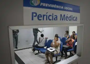 Sala de espera da Perícia Médica do INSS, com pacientes aguardando atendimento para solicitar auxílio-doença no Brasil.