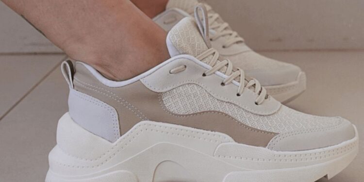 Tênis casual com detalhe do furo extra próximo ao cadarço.