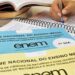 Cadernos oficiais do Enem sobre mesa com estudante escrevendo redação demonstrando técnicas de otimização temporal