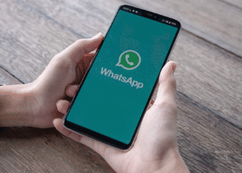 Mãos segurando um smartphone com o logo do WhatsApp na tela, simbolizando o novo recurso de compartilhamento seletivo.