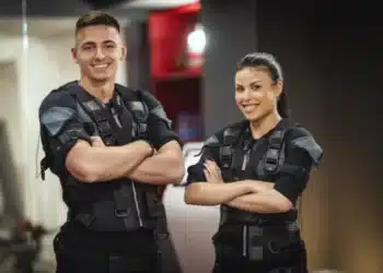 Jovem casal sorridente em uniforme de treino, simbolizando a preparação para o concurso da polícia, com foco na nova regra de altura definida pelo STF.