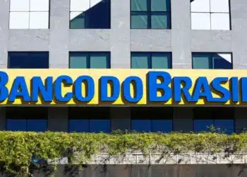 Fachada de uma agência do Banco do Brasil, destacando a placa com o nome da instituição em azul sobre fundo amarelo.