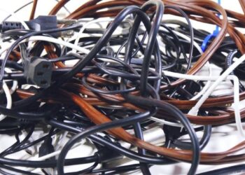 Um emaranhado de cabos e fios de diferentes cores, mostrando a desorganização de carregadores.