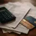 Calculadora, cartões de crédito e boletos sobre a mesa