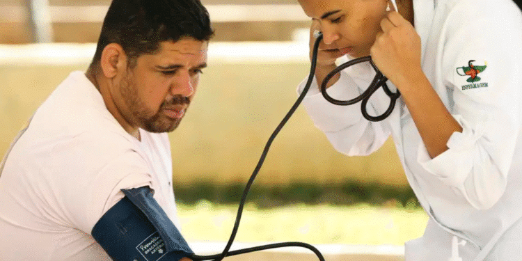 Mulher enfermeira em jaleco branco verifica pressão arterial de homem com aparelho de manguito