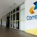 Sede dos Correios com pessoas saindo do prédio enquanto a logo da empresa é visível na imagem. Tema: concurso dos Correios após mudança de presidente.