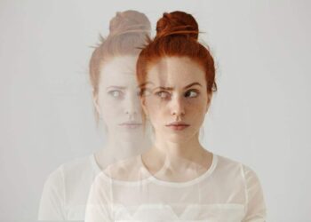 Mulher com expressão de perplexidade e visão desfocada, sugerindo uma experiência de déjà-vu.