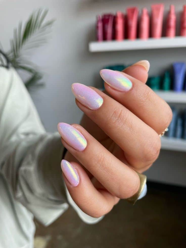 Mão com unhas pintadas de esmalte lilás translúcido e perolado, exibindo um visual moderno.