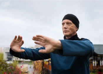 Homem praticando exercícios de samurai ao ar livre para melhorar o equilíbrio e evitar quedas em idosos.