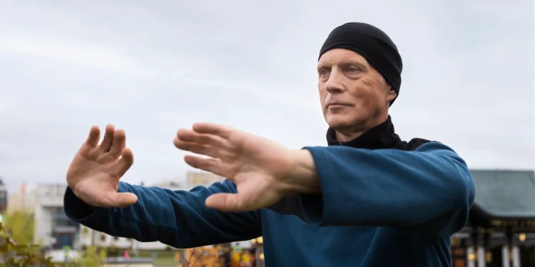 Homem praticando exercícios de samurai ao ar livre para melhorar o equilíbrio e evitar quedas em idosos.