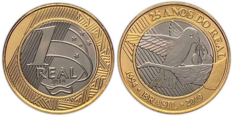 Close-up da moeda de 1 real comemorativa aos 25 anos do plano real, com a figura do beija-flor.