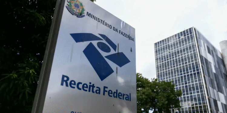 Placa da Receita Federal com edifício moderno ao fundo, Ministério da Fazenda Brasil